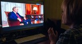 Rusė žiūri į Putiną televizoriuje (nuotr. SCANPIX)