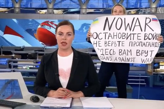 Moteris įsiveržė į propagandinio Rusijos kanalo studiją: prieš kameras iškėlė plakatą (nuotr. stop kadras)