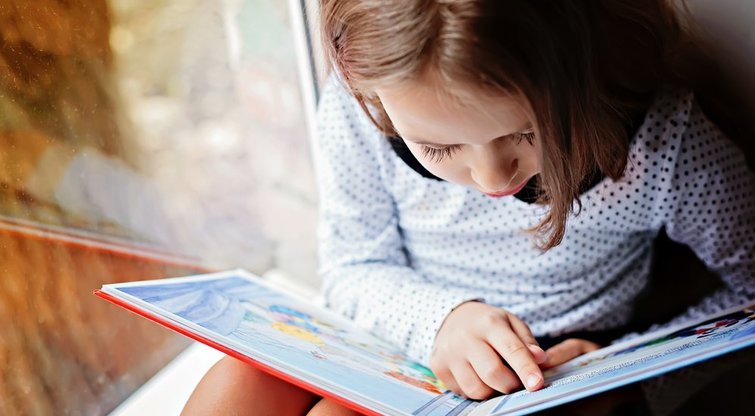 Vaikas skaito knygą (nuotr. Shutterstock.com)