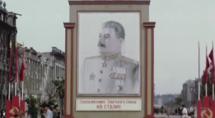 Berlynas 1945-ųjų liepą: skubantys miestiečiai ir Stalino portretas (nuotr. YouTube)