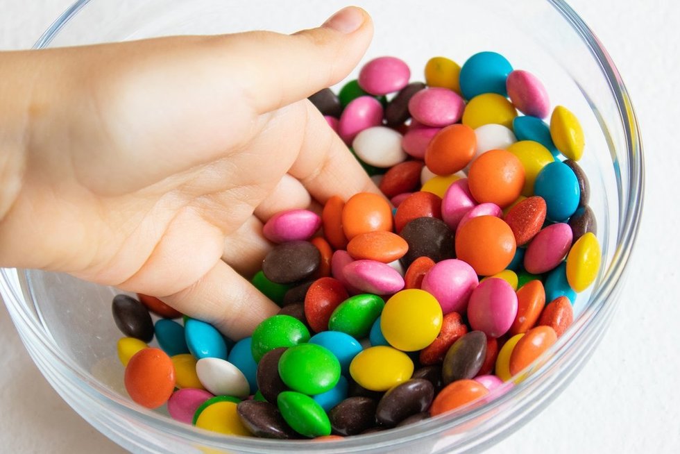 Vaikas valgo saldainius (nuotr. 123rf.com)